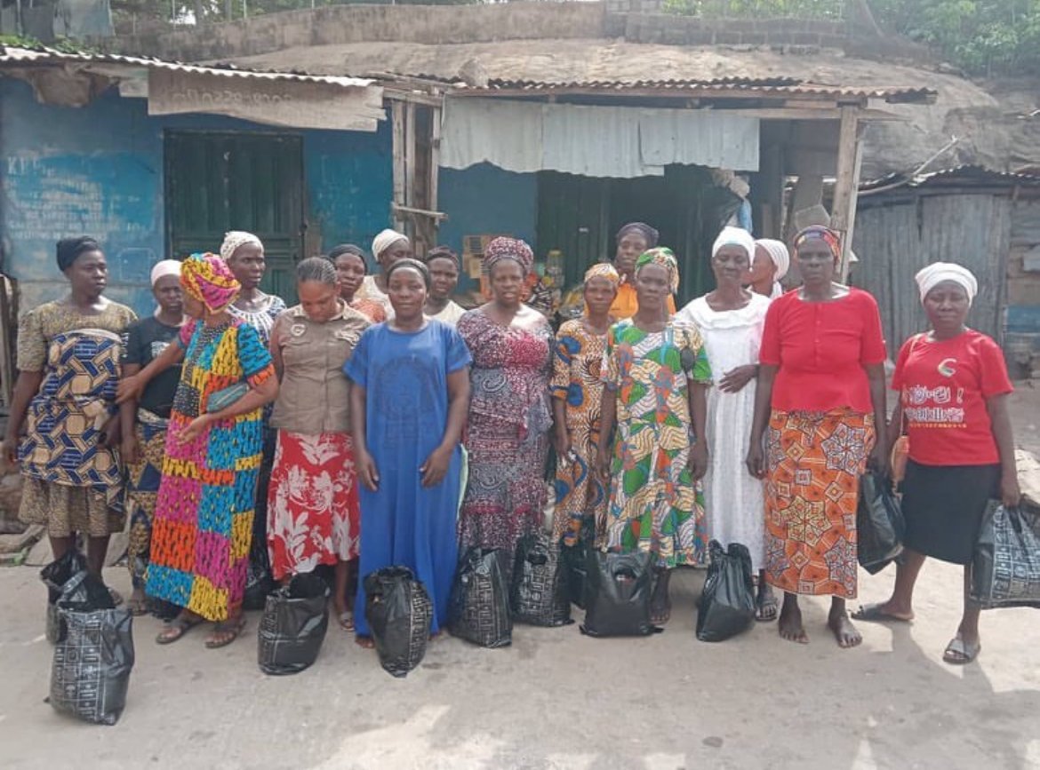 A group of women holding bags of supplies at a Dorothy's Care Foundation distribution.