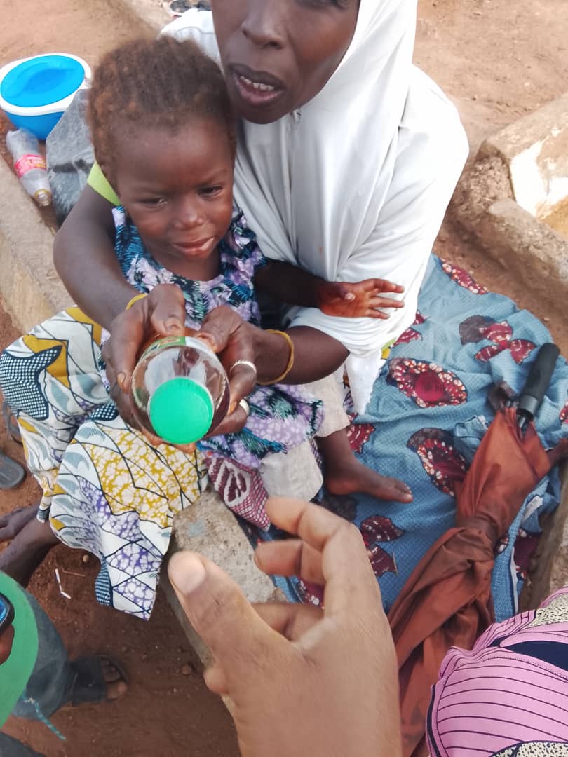 A mother and child receiving medicine during community outreach.